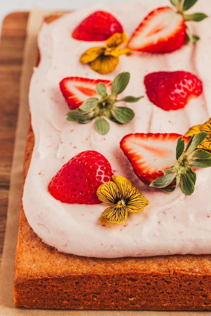 An up close of the decorations for a strawberry sheet cake.